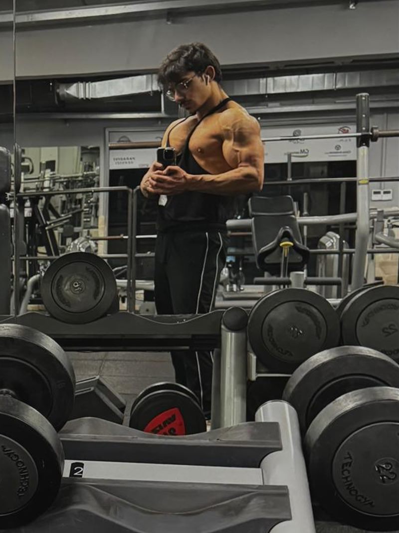 Damiano Tropea in palestra, davanti allo specchio, tra manubri e pesi